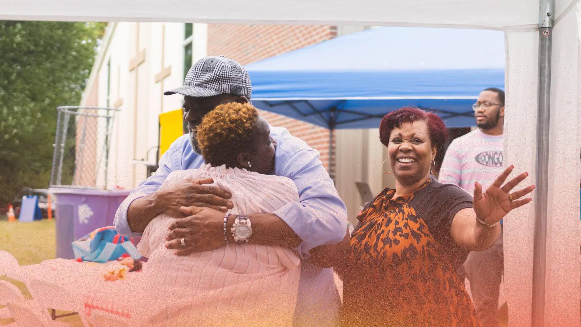 Church members greeting one another with a hug and a smile outdoors
